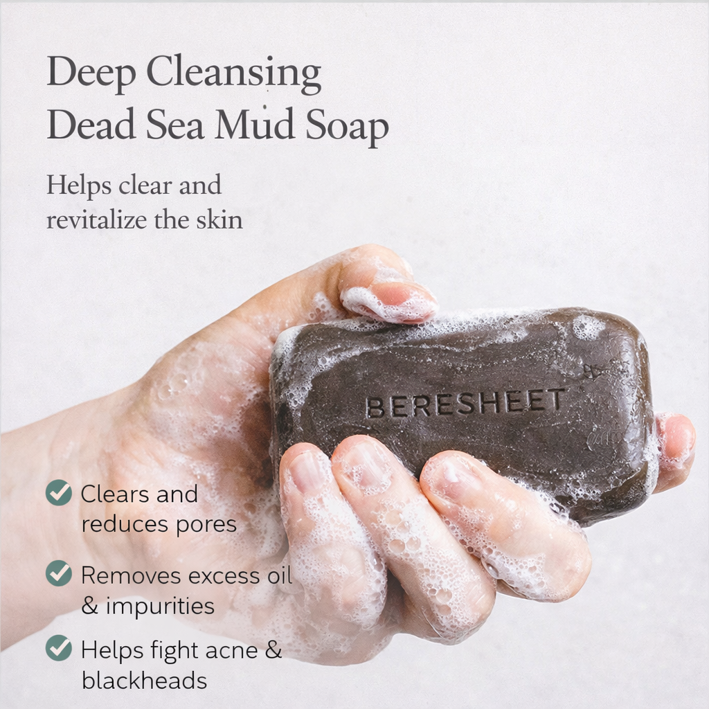 Hand holding a bar of Bereshet Dead Sea Mud Soap with text about its benefits on a white background