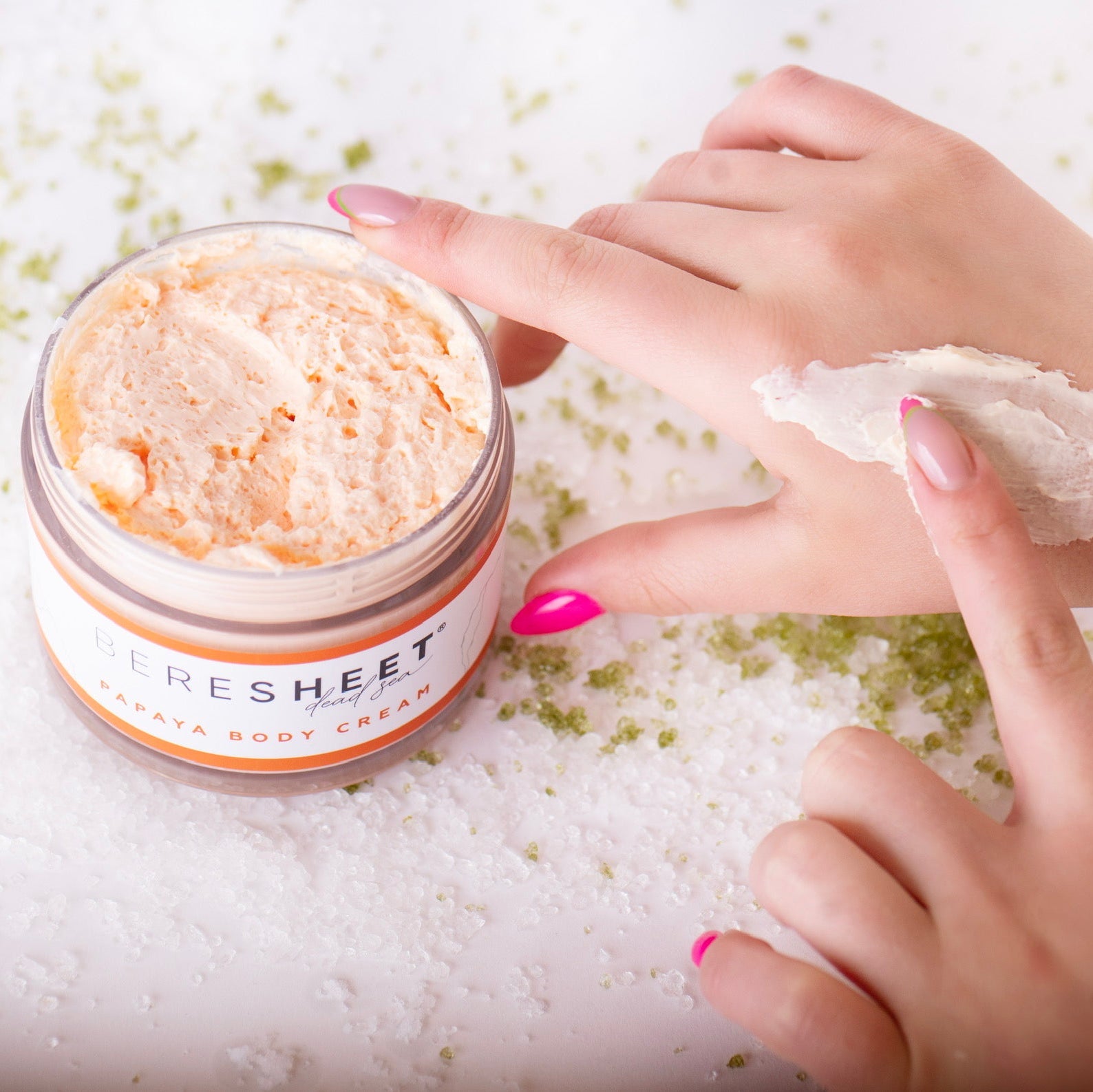 Person applying a product from a jar labeled 'Fresheet' on their hand.