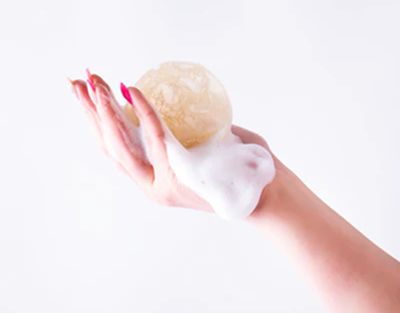 Hand holding a bar of soap with a white background