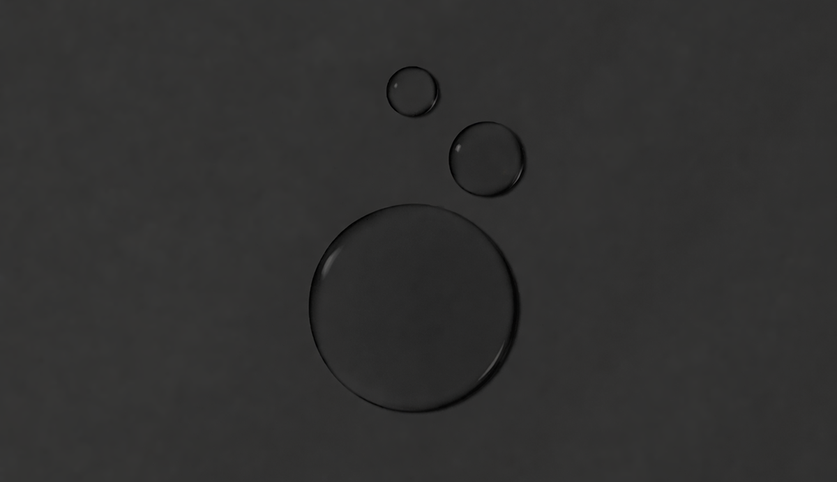 Three circular water droplets on a black background