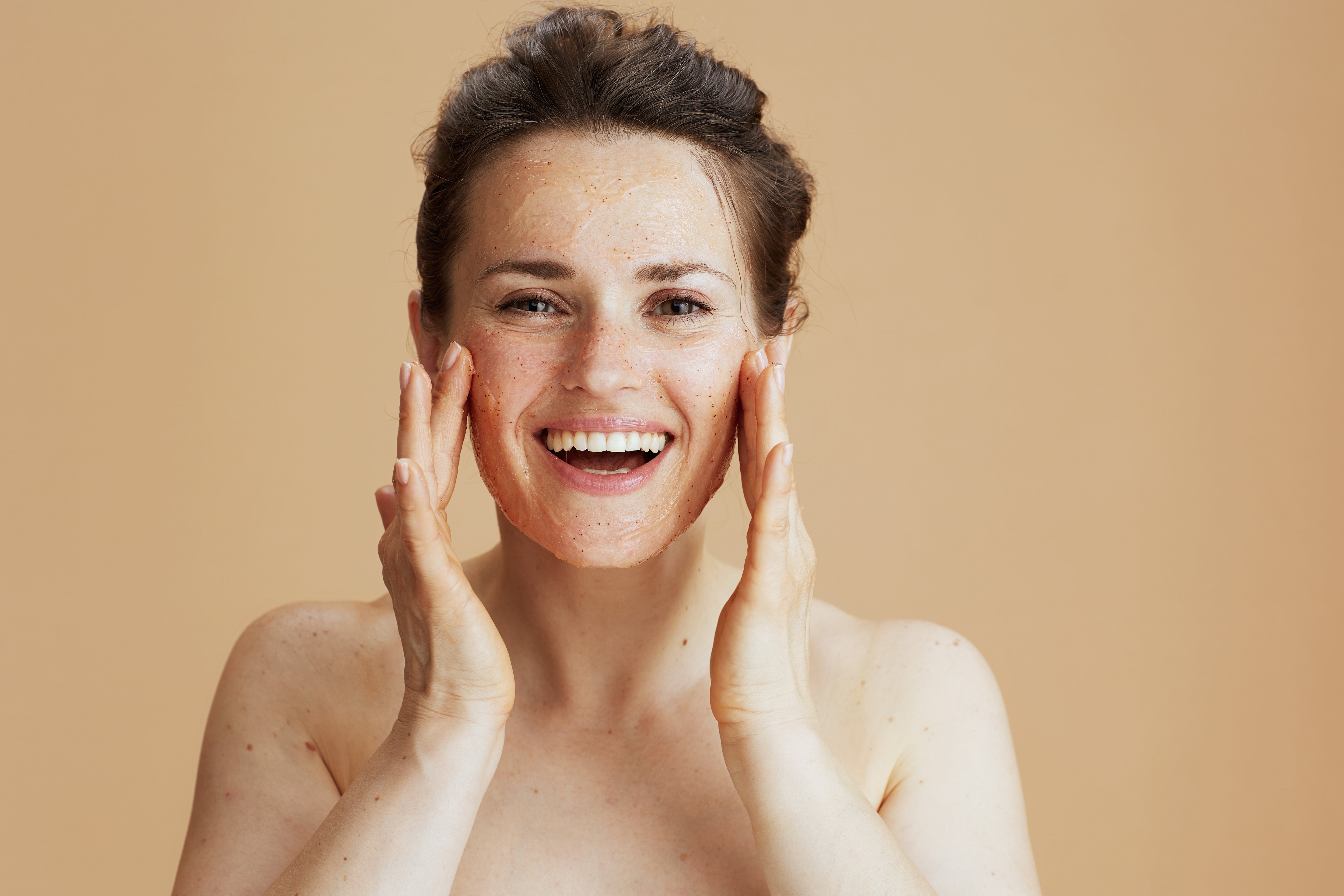 Woman touching her face with a beige background