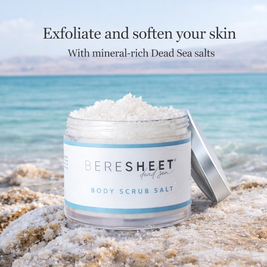 Jar of Beresheet Dead Sea body scrub salt on a beach with text about exfoliating and softening skin.