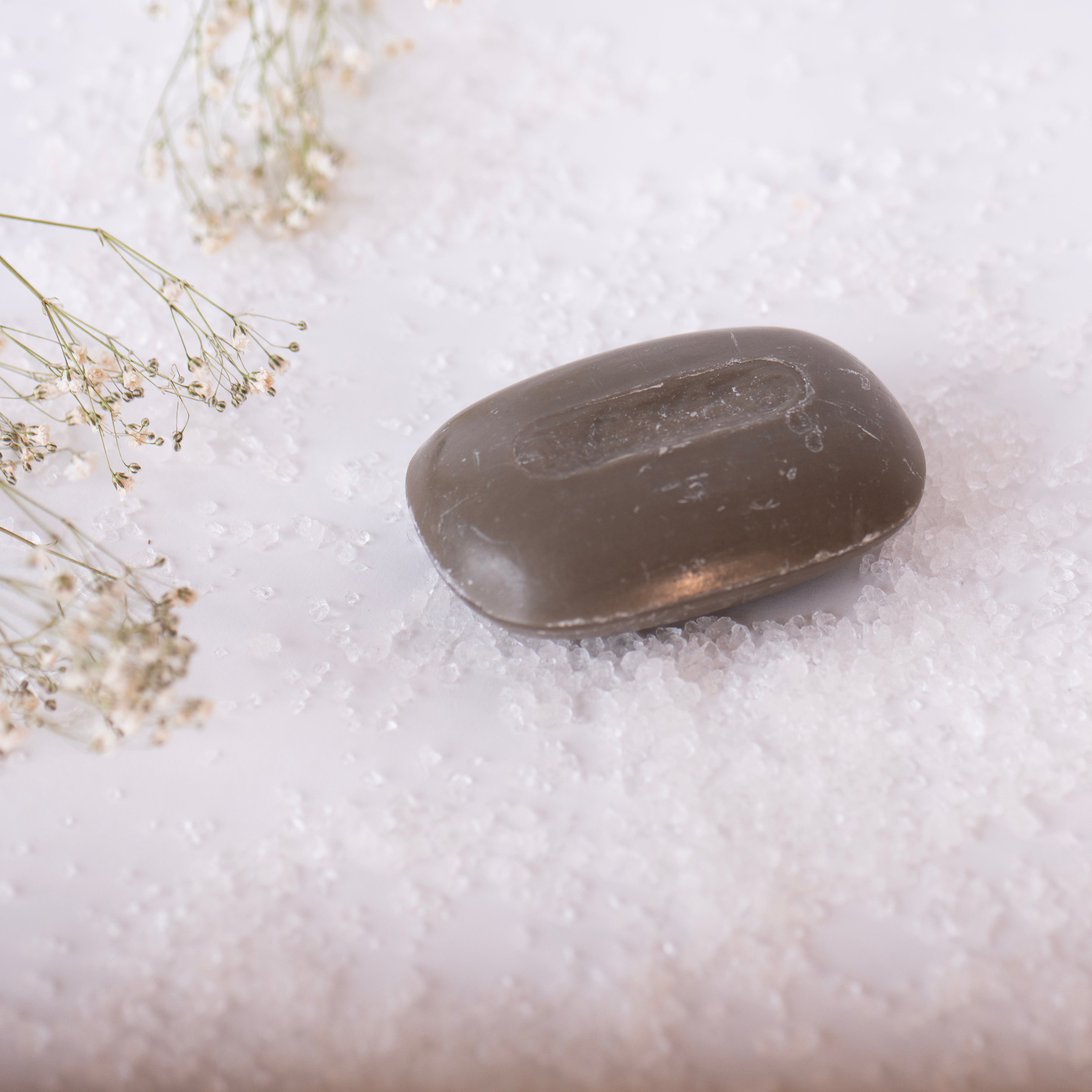 Bar of soap on a white surface with small flowers