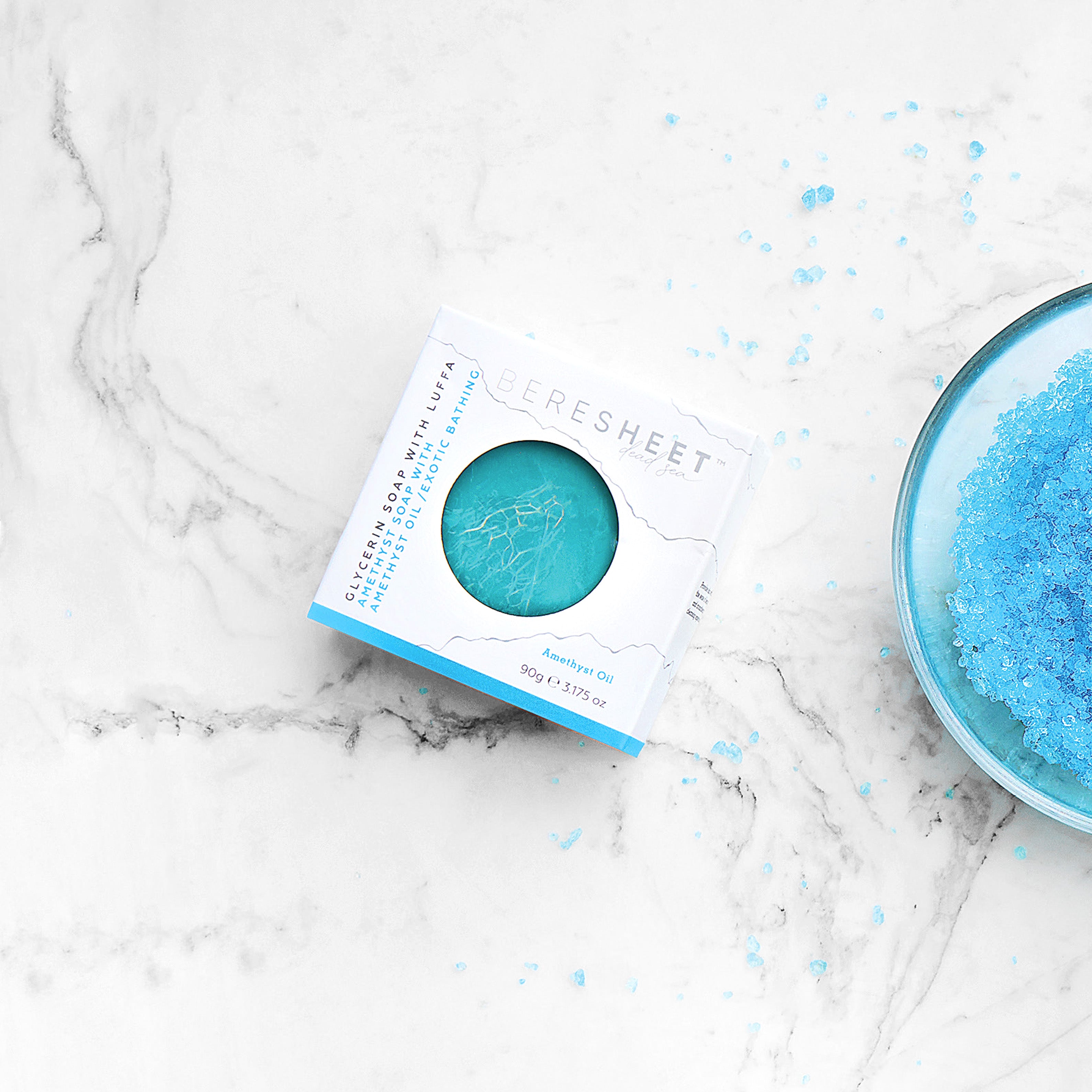 Blue bath salt with packaging on a marble surface