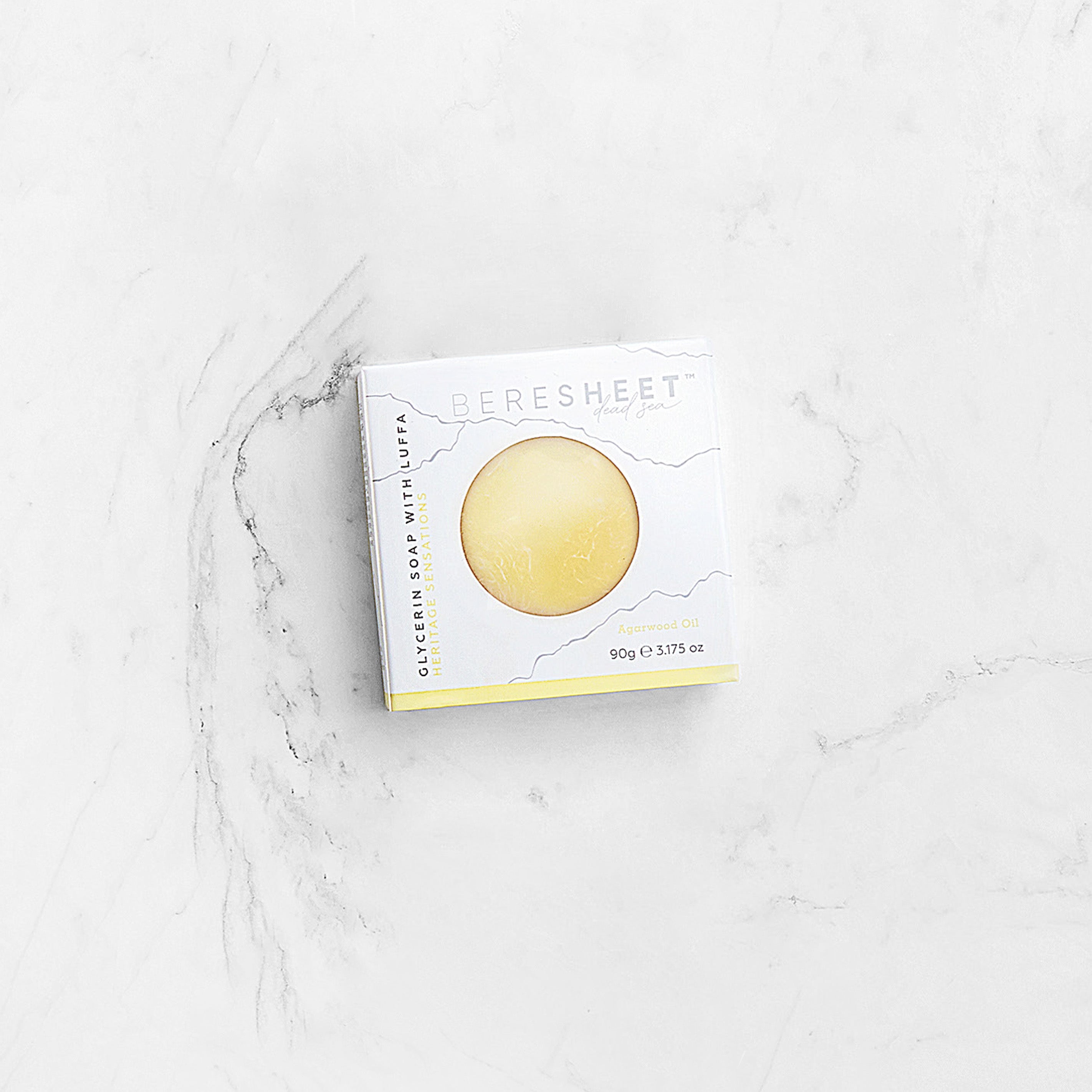 Box of a golden soap bar on a marble surface