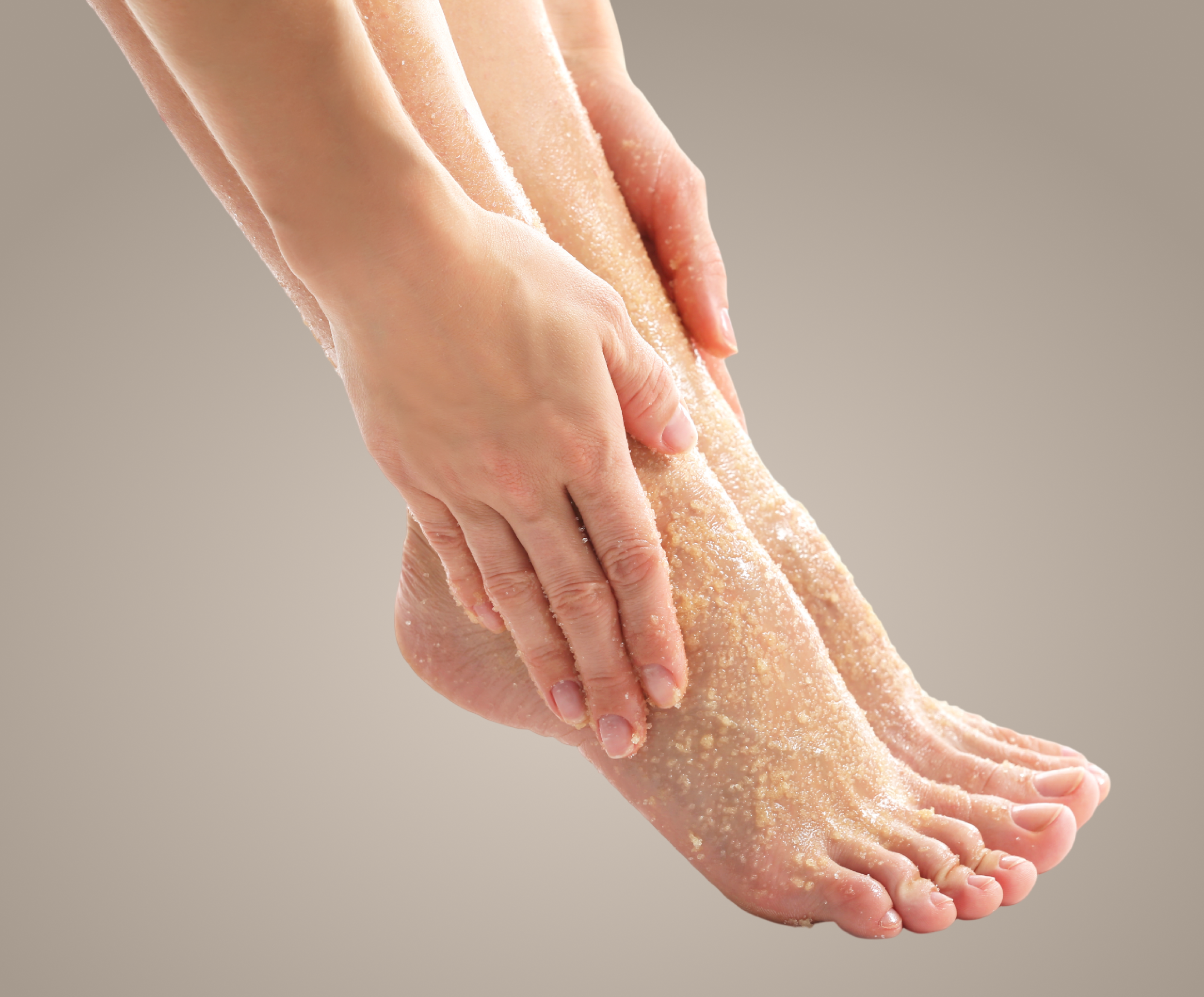 Person massaging their foot against a neutral background